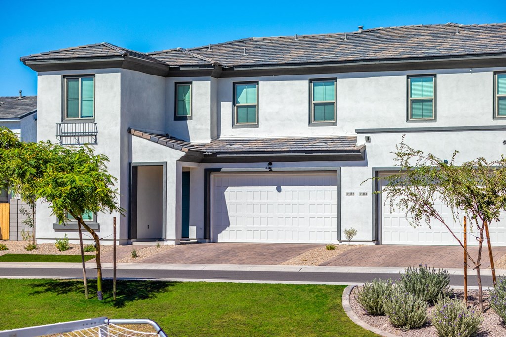 a white house with a garage door in front of it