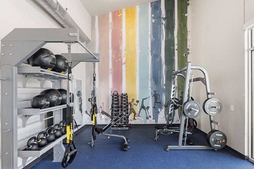 a workout room with weights and a colorful wall mural at SECOND AVE COMMONS | BRAND-NEW, Arizona