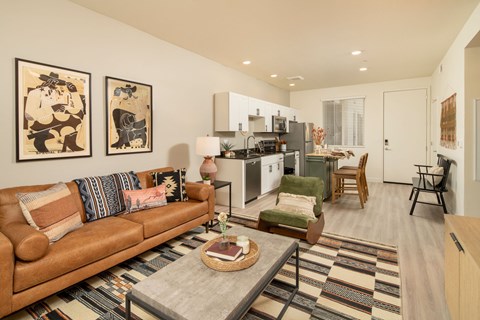 A living room with a brown couch and a rug.