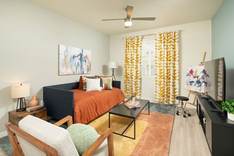 A bedroom with a bed, chair, and painting on the wall.