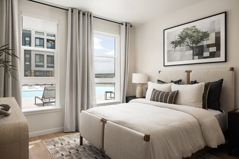 A bedroom with a large bed and a view of the water.