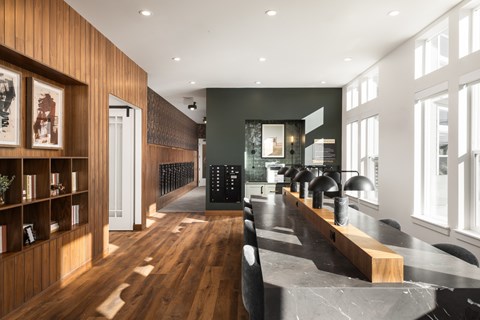 A modern dining room with a long table and chairs.