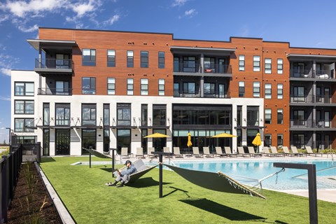 A large building with a pool in front of it.