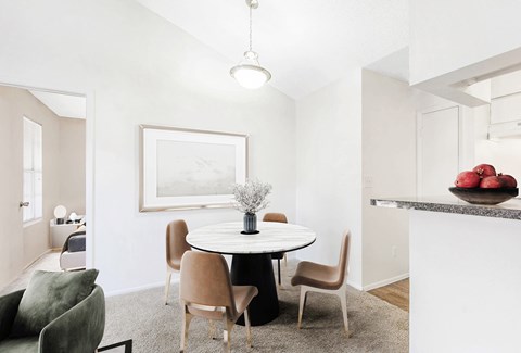 A white dining room with a round table and chairs.