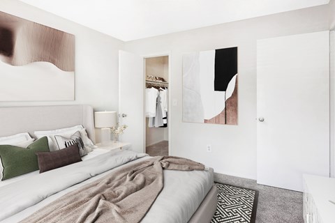 A bedroom with a large bed and a painting on the wall.