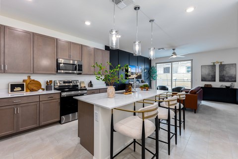 A modern kitchen with a white island and brown cabinets.
