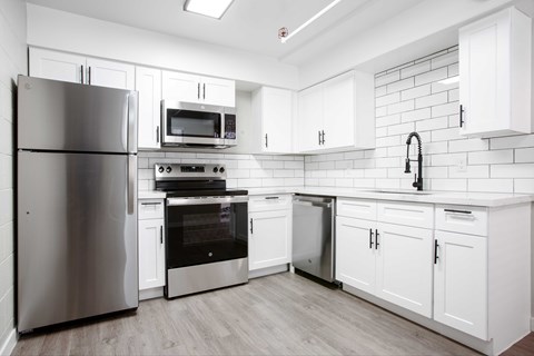 A modern kitchen with white cabinets and stainless steel appliances.