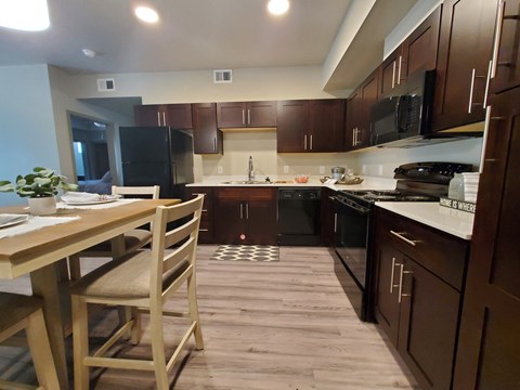 a kitchen with dark wood cabinets and a table and chairs