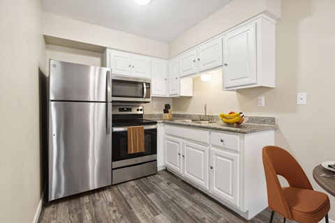 a kitchen with stainless steel appliances and white cabinets