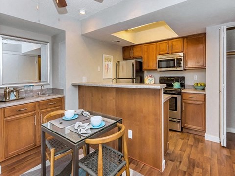 a kitchen with wooden cabinets and a table with chairs