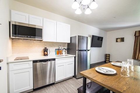 a kitchen with stainless steel appliances and a wooden table