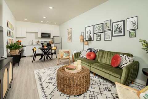A living room with a green couch and a wicker table.