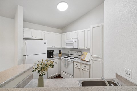 a white kitchen with white appliances and white cabinets