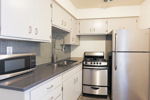 a kitchen with stainless steel appliances and white cabinets