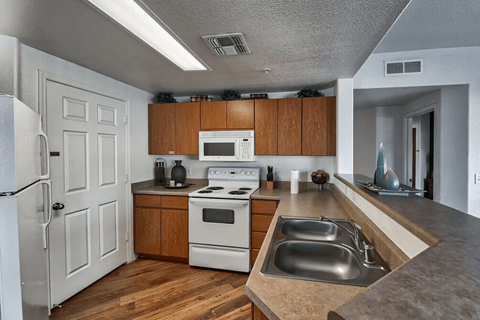 a kitchen with white appliances and wooden cabinets