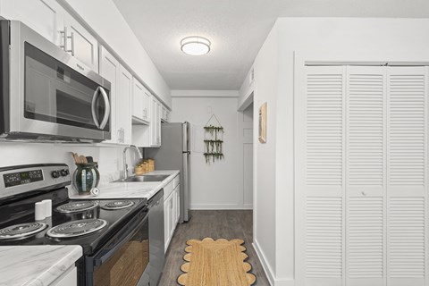 a kitchen with white cabinets and a stove and a microwave