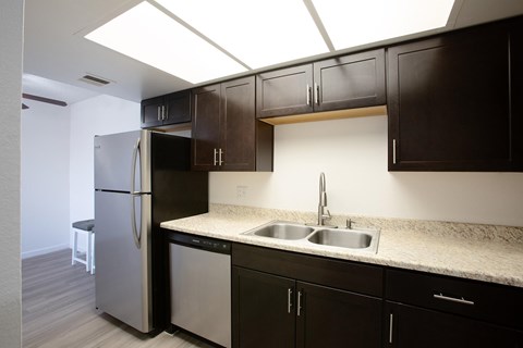 A kitchen with a sink and a refrigerator.