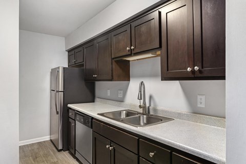 a kitchen with stainless steel appliances and dark wood cabinets