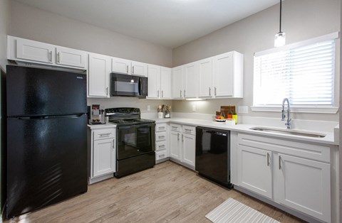 a kitchen with black appliances and white cabinets