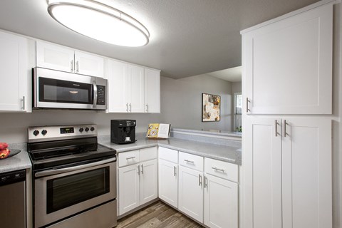 a kitchen with stainless steel appliances and white cabinets