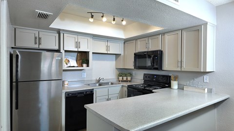 a kitchen with stainless steel appliances and white cabinets