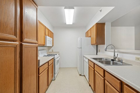 the preserve at ballantyne commons apartment kitchen with white appliances and wooden cabinets
