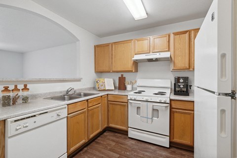 the preserve at ballantyne commons apartment kitchen with white appliances and wooden cabinets
