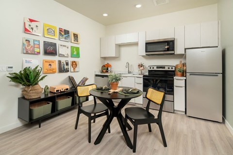 a kitchen and dining area with stainless steel appliances and a table and chairs