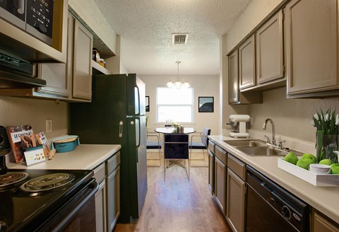 a kitchen with black appliances and white counter tops and a black refrigerator