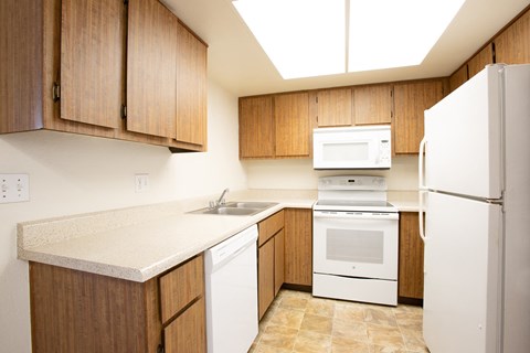a kitchen with white appliances and wooden cabinets