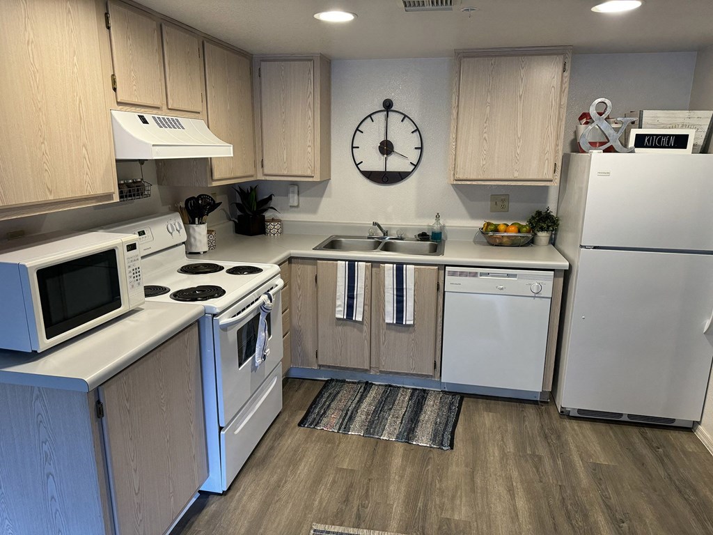 a kitchen with white appliances and a clock on the wall