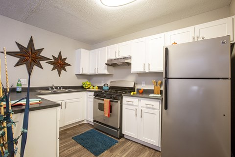 a kitchen with stainless steel appliances and white cabinets
