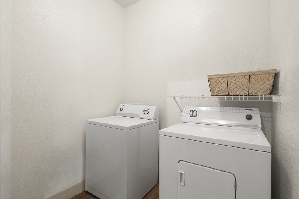 A white washing machine and dryer in a laundry room.