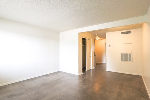 an empty living room with white walls and a concrete floor