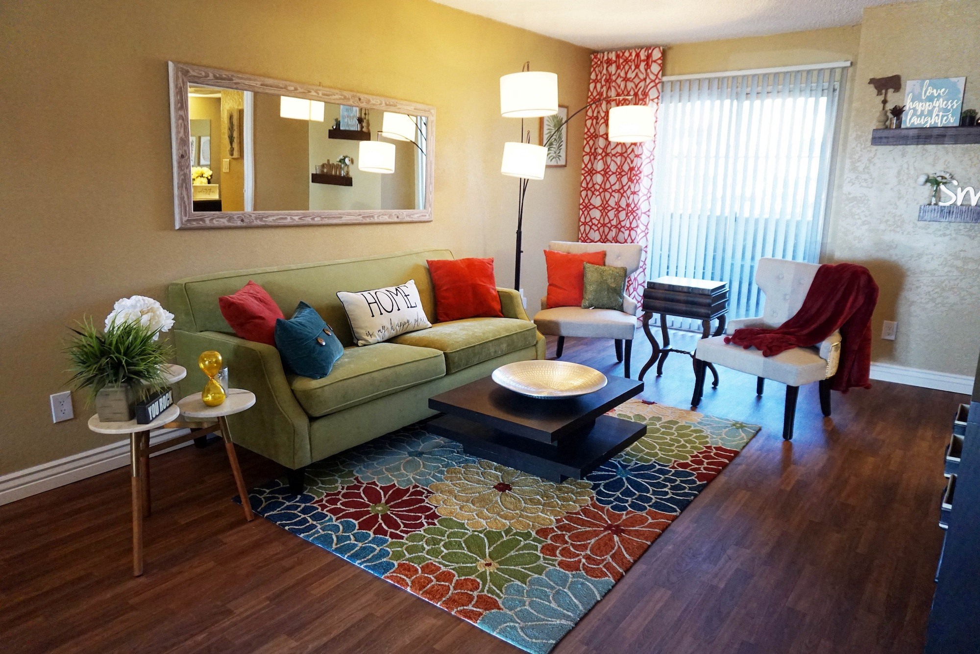 a living room with a green couch and a rug