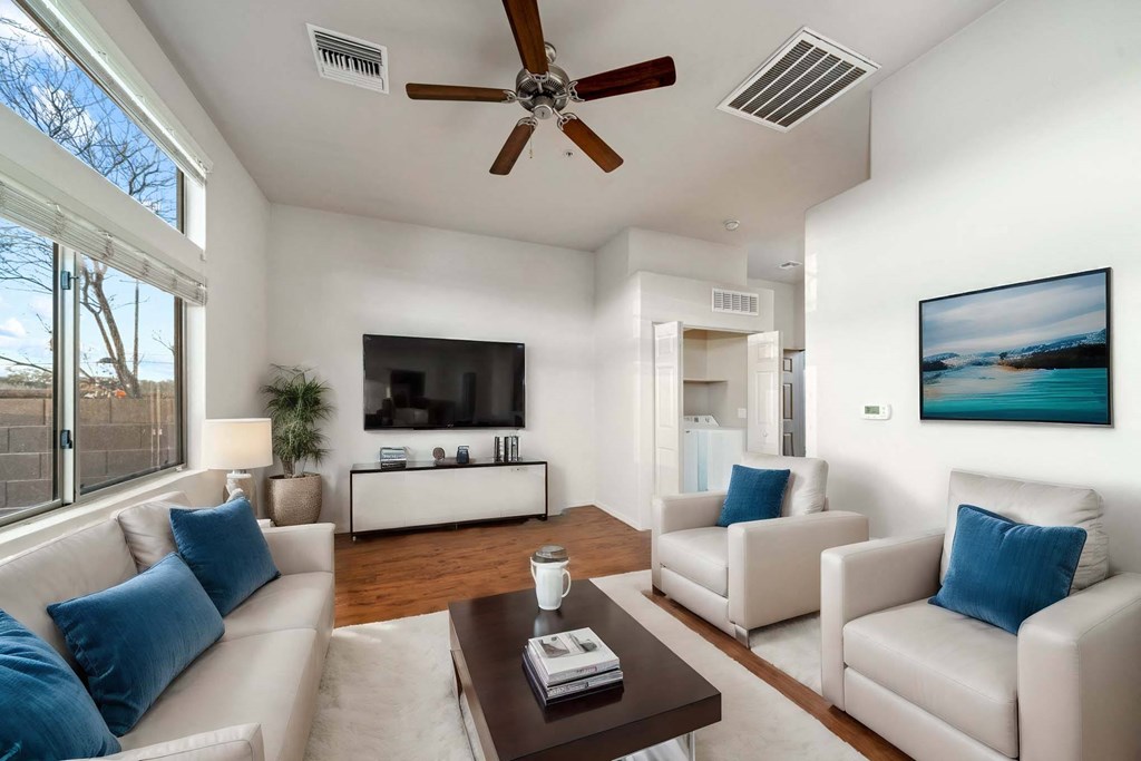 Living Room with Ceiling Fan and Washer and Dryer at Avilla Preserve Apartment Homes in Tucson Arizona