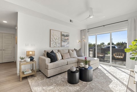 A living room with a couch, a table, and a painting on the wall.