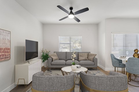 a living room with couches and chairs and a ceiling fan