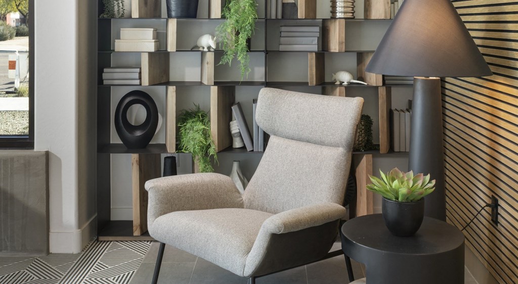 a chair in front of a bookshelf in a living room