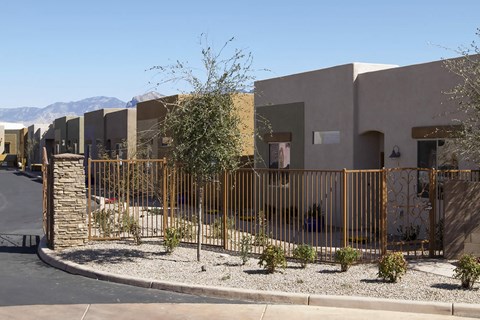 A row of houses with a metal fence in front.