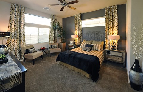 A bedroom with a large bed and a ceiling fan.