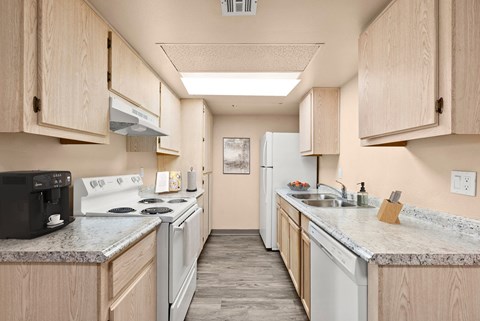 a kitchen with white appliances and granite counter tops and wooden cabinets