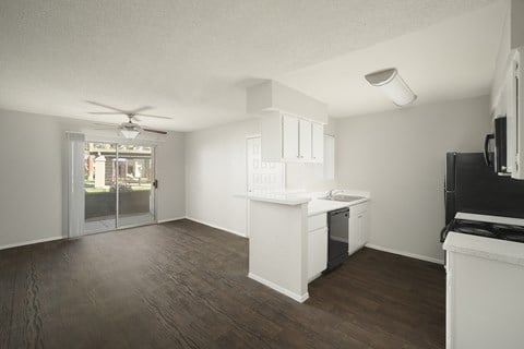 an empty kitchen and living room with a door to a patio