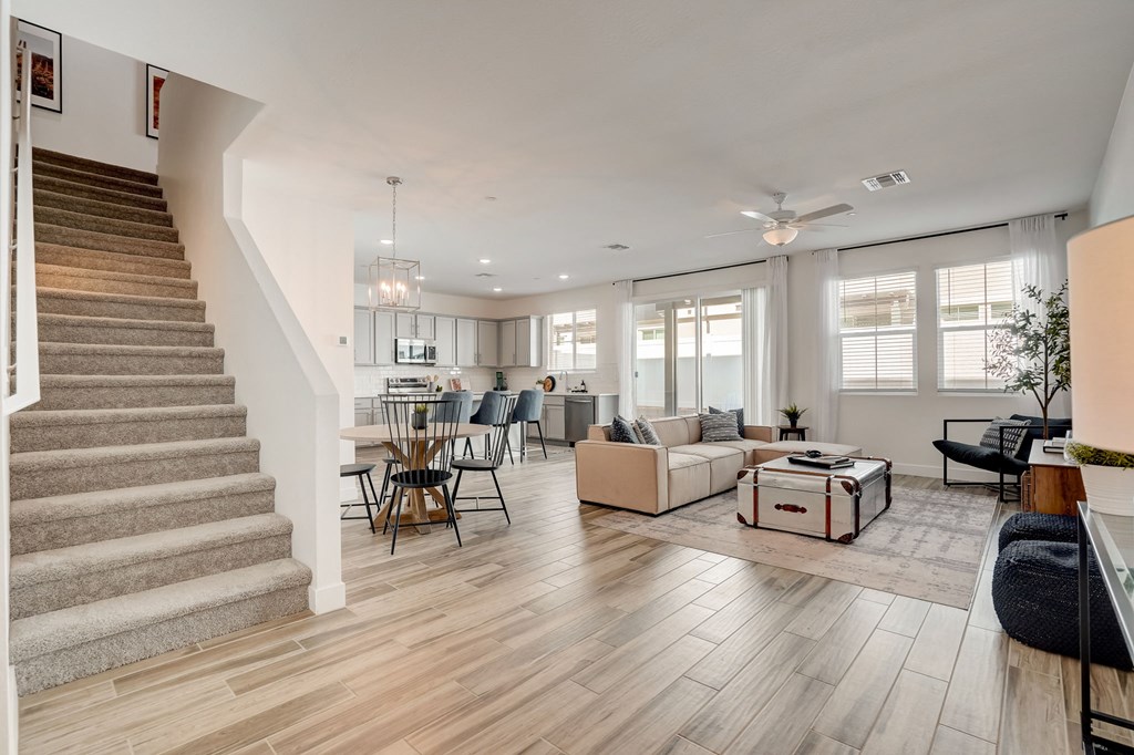 a living room with a staircase and a dining room and a kitchen
