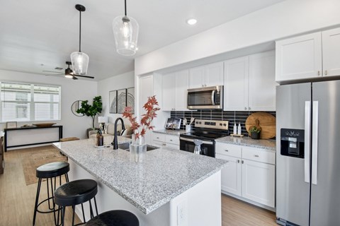 A kitchen with a granite countertop and white cabinets.