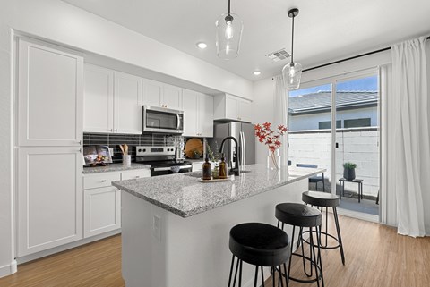 A kitchen with white cabinets and a granite countertop.