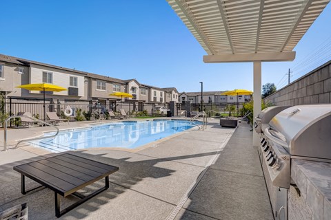 A pool area with a bench and a building in the background.