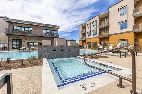 A swimming pool in front of apartment buildings.