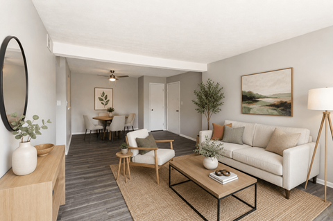 A living room with a white couch, a coffee table, and a painting on the wall.