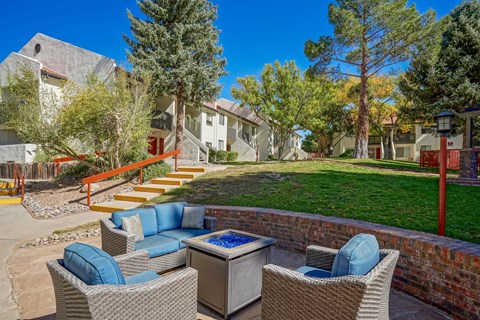 A patio with a hot tub and chairs.